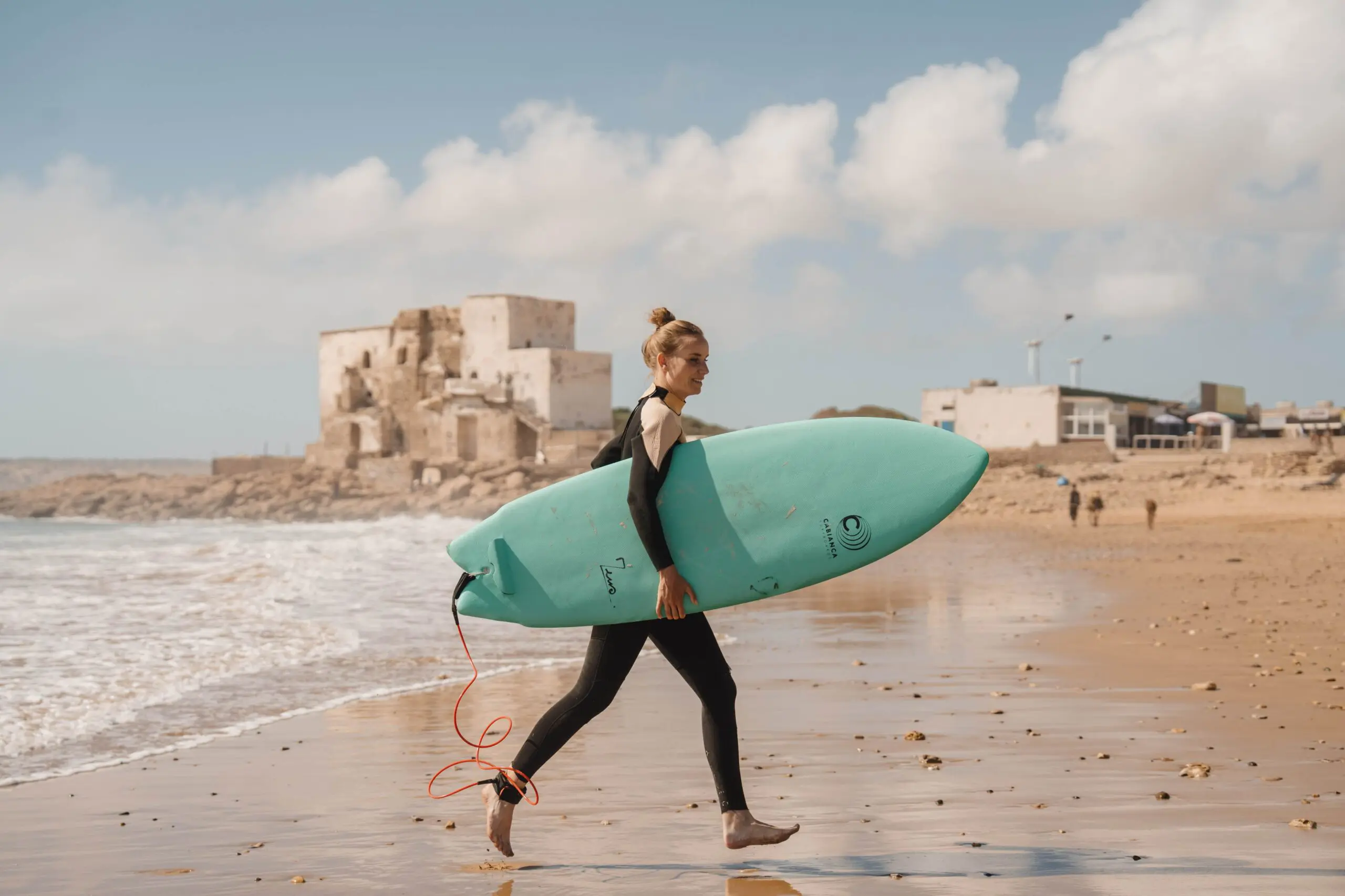 Surferin, die am Strand spaziert.